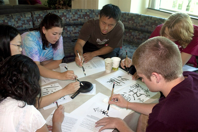 Students writing Chinese calligraphy