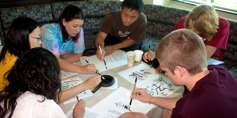 A group of students writing Chinese Calligraphy